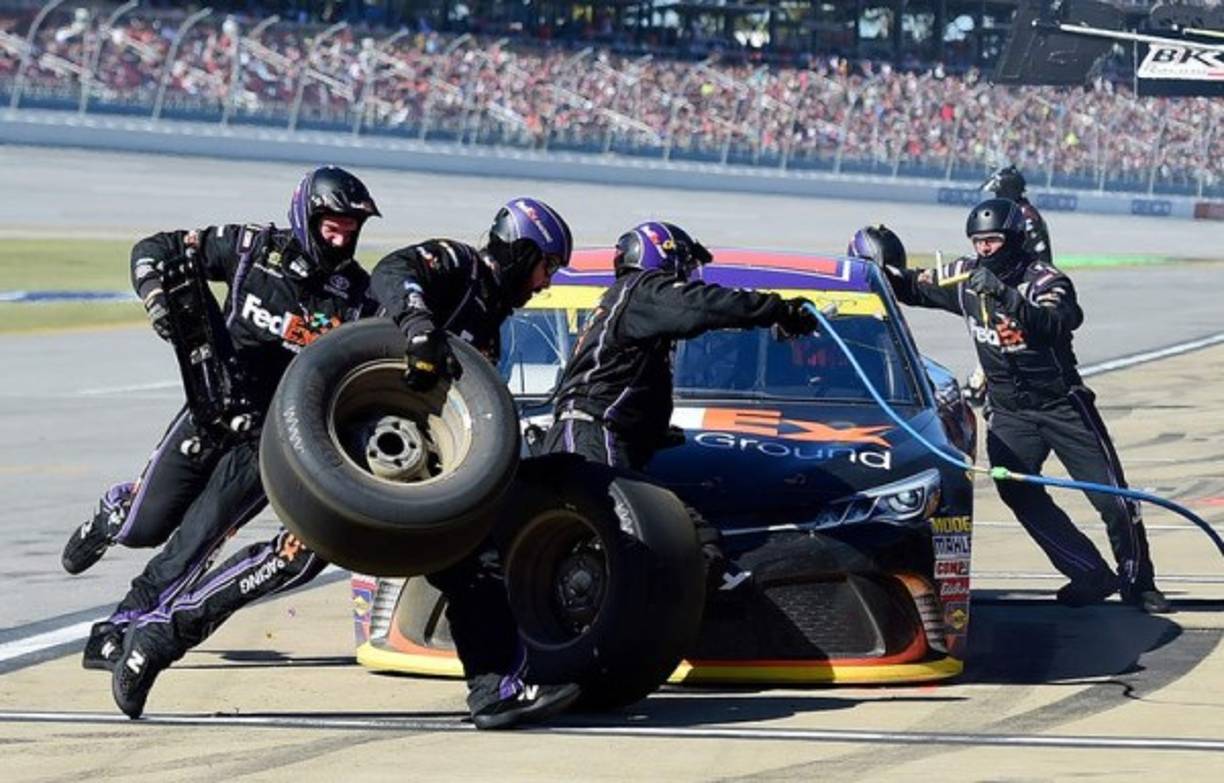 NASCAR. Trabajo en equipo. Denny Hamlin llega a los pits y sus compañeros FedEx Ground Toyota le dan la asistencia en la Sprint Cup Series Hellmann’s 500.