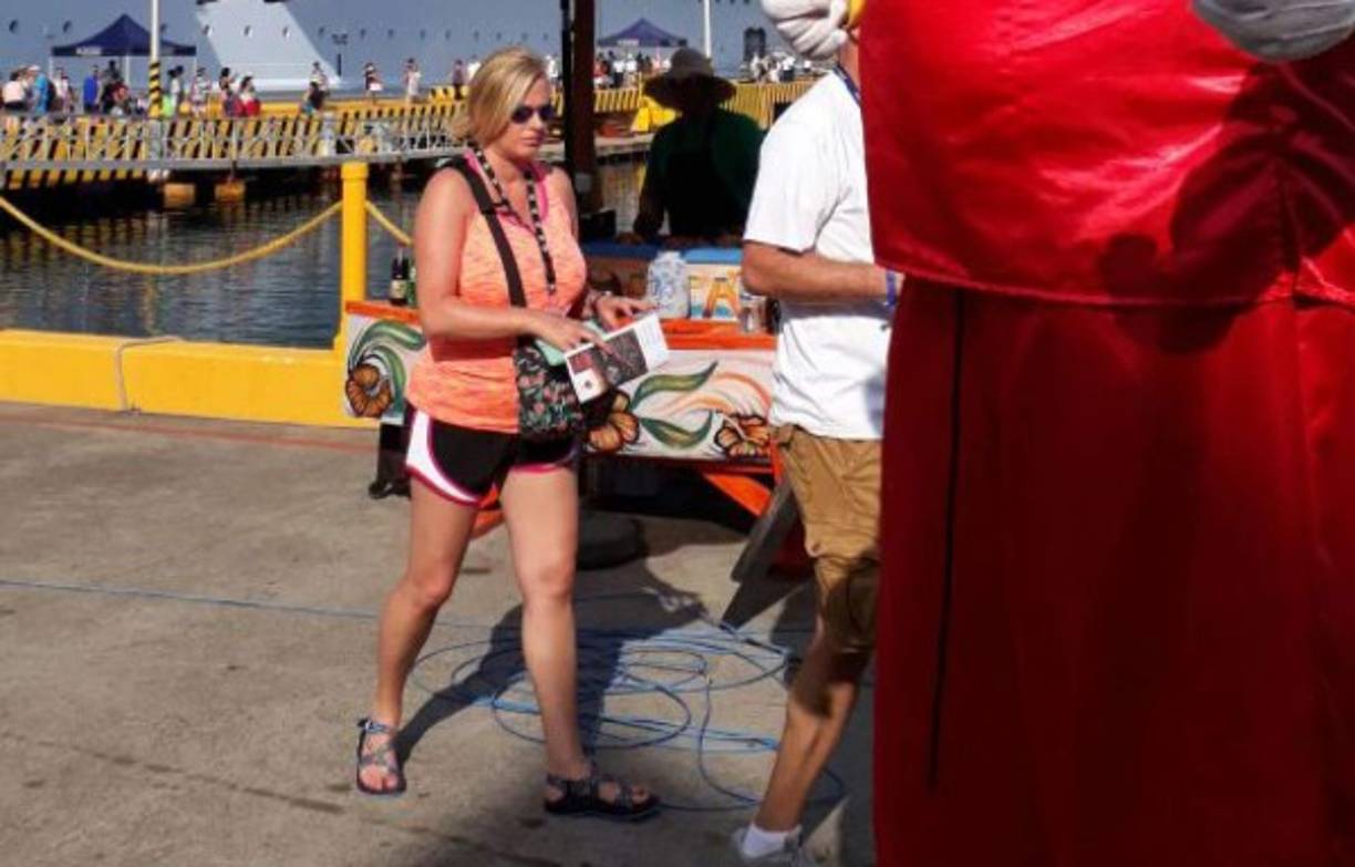 Una joven turista camina hacia un sitio turístico de Roatán después de bajarse del crucero Allure of the Seas.