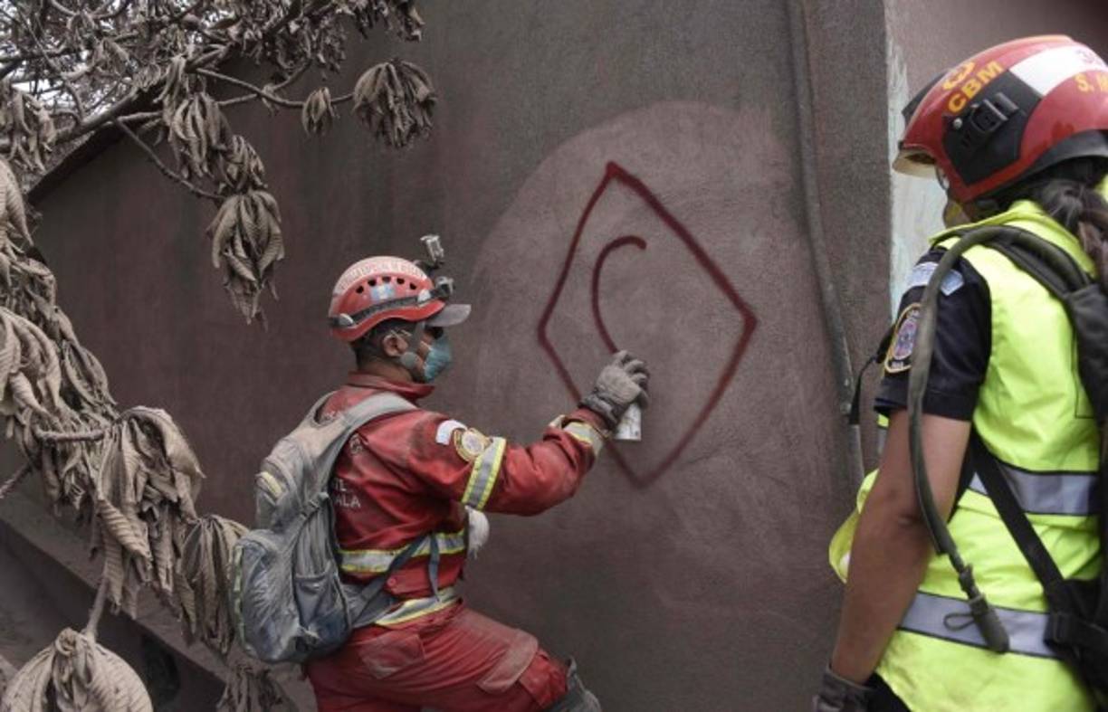 Los rescatistas marcan las casas que ya revisaron en busca de supervivientes.