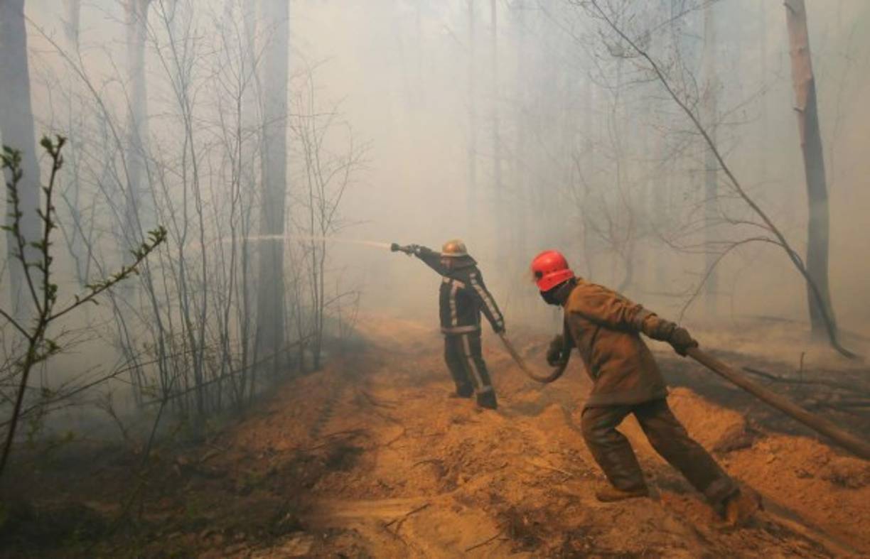 Los bomberos tratando de apagar los incendios forestales.