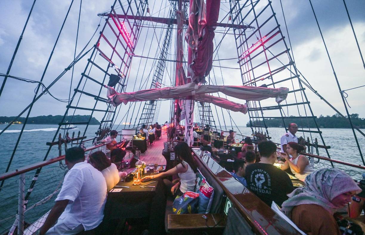 Durante dos horas y media, una quincena de <b>gatos</b> y 130 personas navegan por las inmediaciones de la turística isla de Sentosa, mientras contemplan Singapur y los fuegos artificiales.