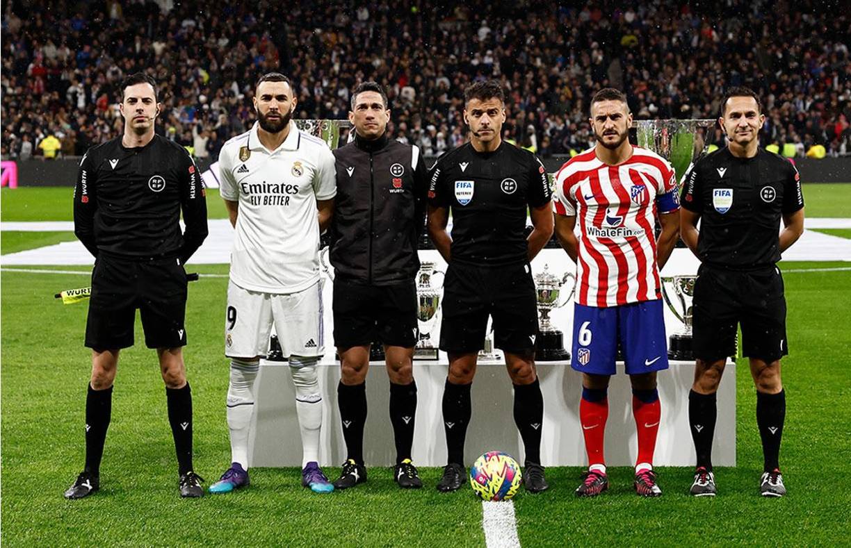 Los capitanes Karim Benzema y Koke posando junto a la cuarteta arbitral encabezada por Jesús Gil Manzano.