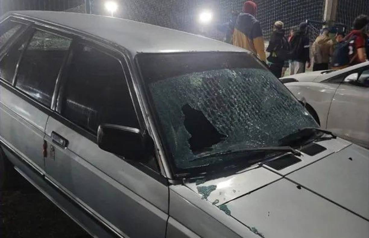 Varios vehículos situados en el estacionamiento de las canchas sufrieron daños por las balas.