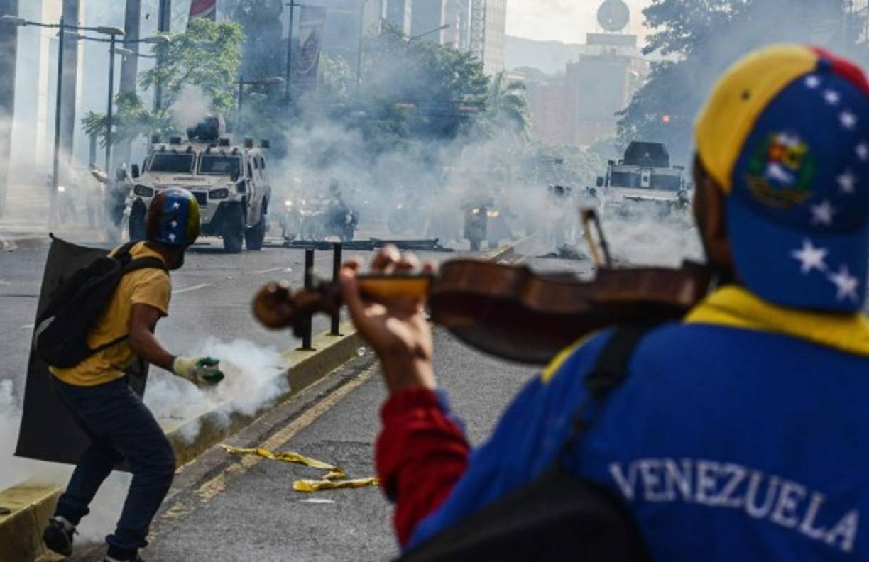 Esta imagen de un violinista en medio de las protestas también fue elegida como una de las mejores fotos del año.