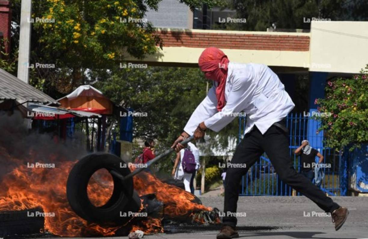 Momentos en que los jóvenes quemaban llantas frente al centro universitario.
