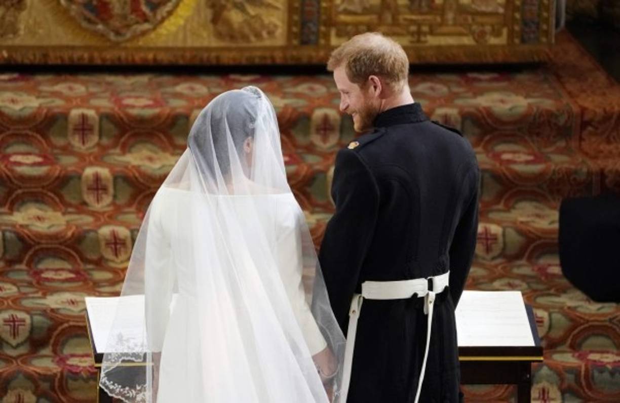 El Príncipe Harry de Gran Bretaña, Duque de Sussex (R) se encuentra con la actriz estadounidense Meghan Markle (L) en el altar de la Capilla de San Jorge, en el Castillo de Windsor, en Windsor, durante su ceremonia de boda.<br/>Owen Humphreys / PISCINA / AFP