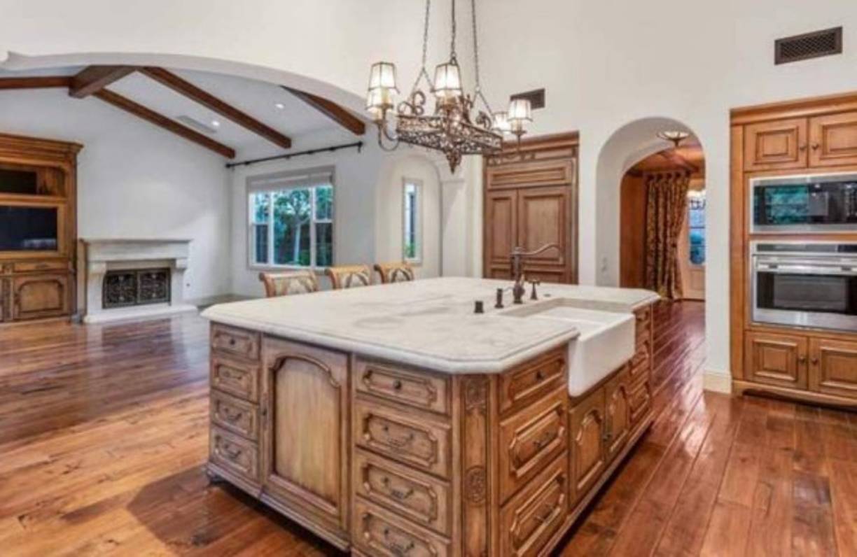 Aunque estaba casi vacía, se puede apreciar que gran parte del mobiliario elegido seguía un estilo rústico, con acabados en madera y piedra pulida. No hay que perder de vista el detalle de las coloridas baldosas en la cocina. -