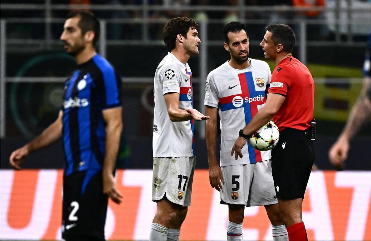 Marcos Alonso y Sergio Busquets le reclaman le piden explicaciones al árbitro esloveno Slavko Vincic.