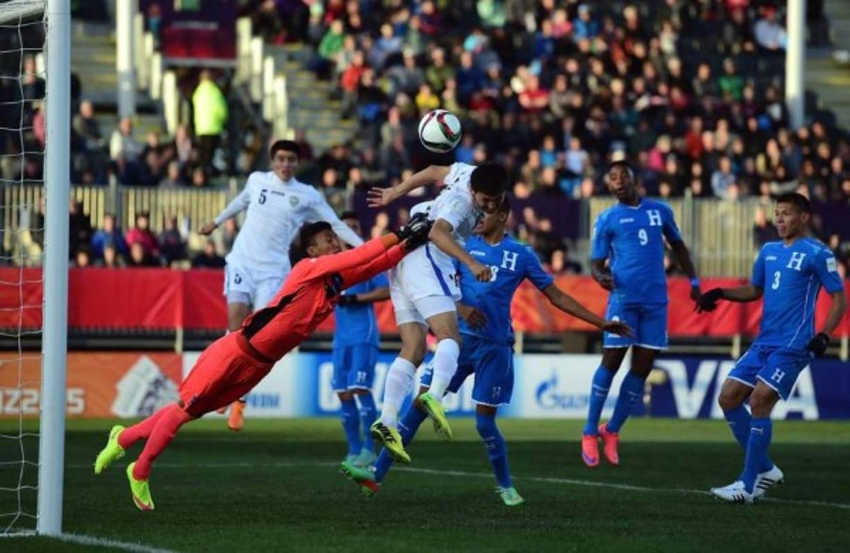 El guardameta hondureño Roberto López sale a despejar de un puños un ataque de Uzbekistán.
