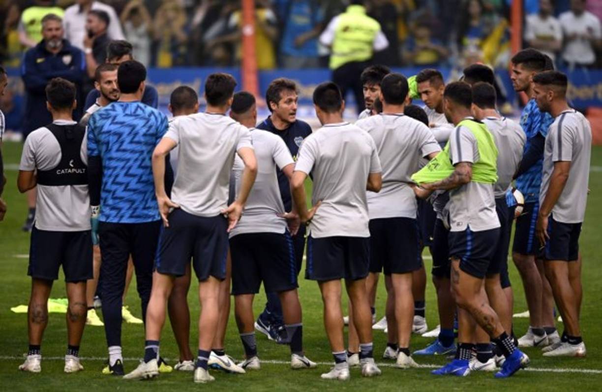 Guillermo Barros Schelotto conversando con los jugadores de Boca Juniors en el centro del campo antes del entrenamiento.