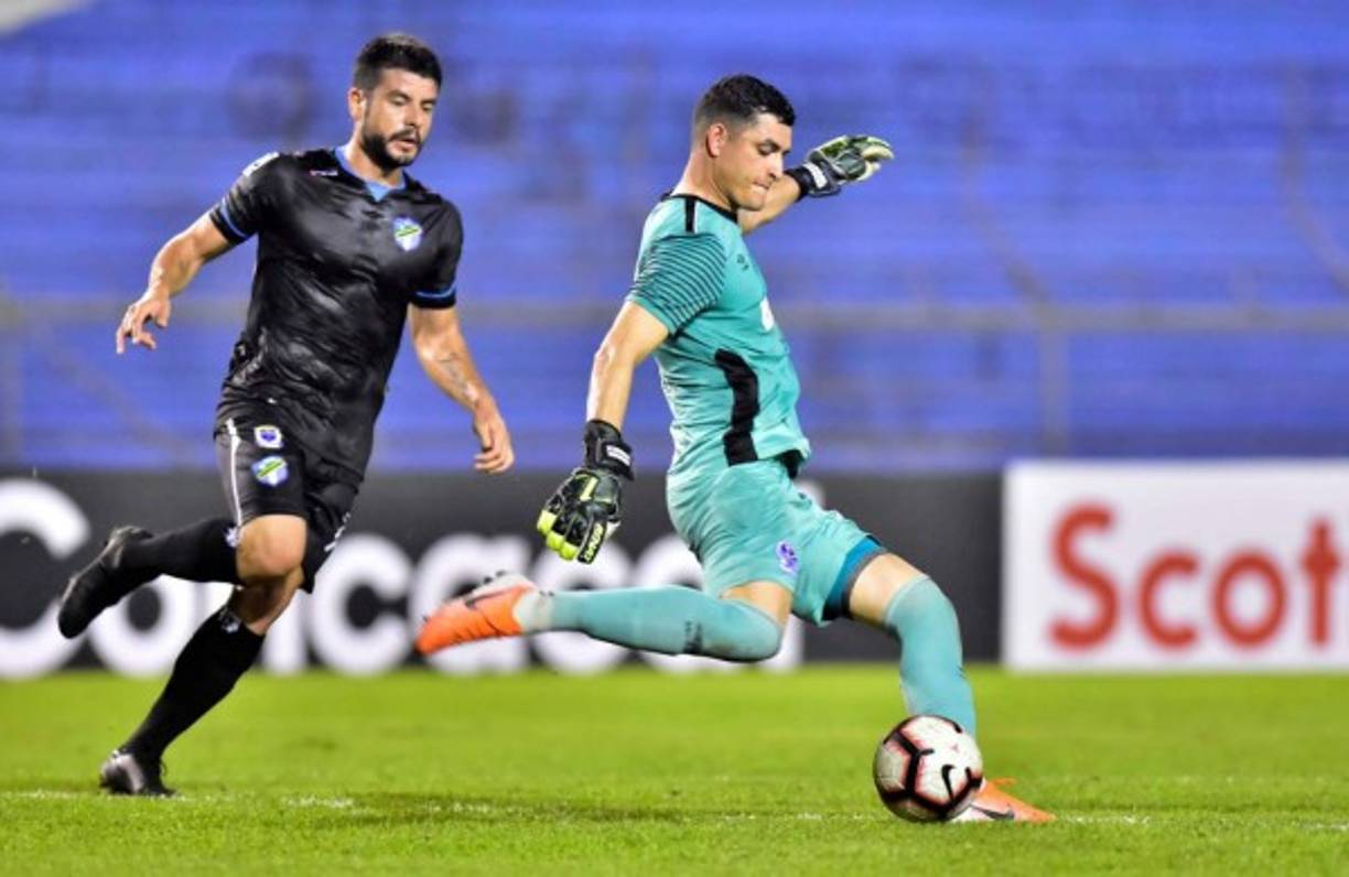 El portero Harold Fonseca se dispone a patear el balón ante la marca del uruguayo Maximiliano Lombardi.