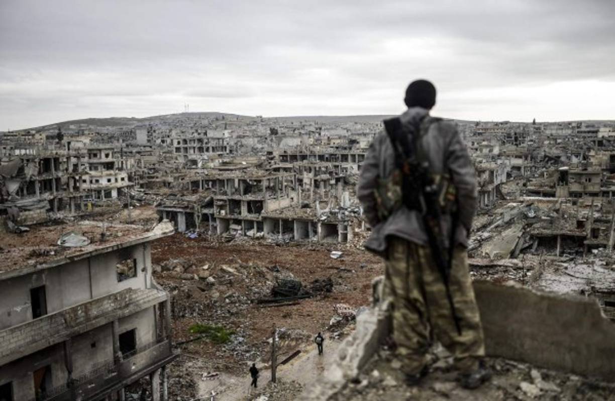 Un miliciano kurdo observando el estado de devastación en que quedó la ciudad de Kobane, en Siria, tras el asedio de cuatro meses a que le sometió Isis.