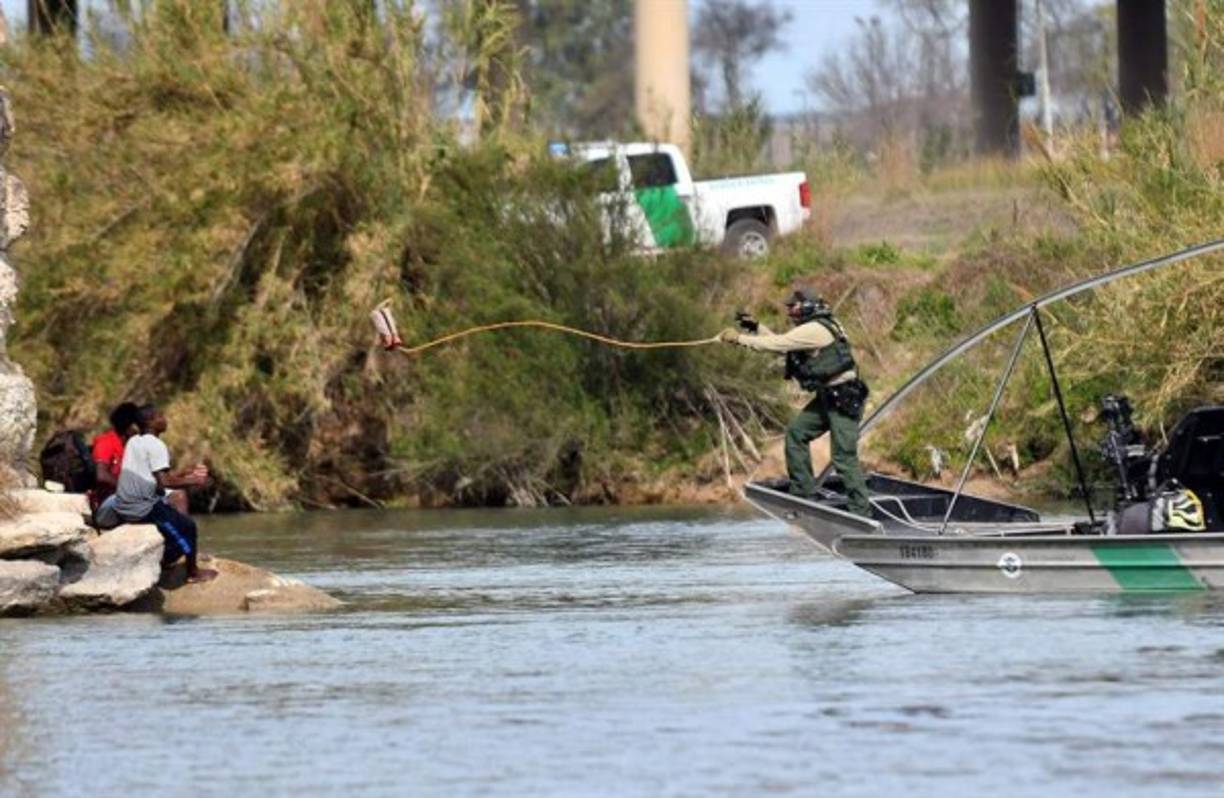 Los agentes lanzaron una cuerda a los migrantes para rescatarlos.