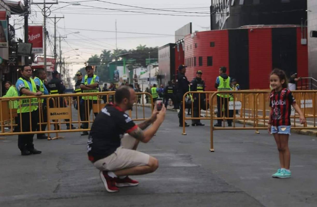 Un orgulloso padre le toma una foto a su hija aficionada del Alajuelense.