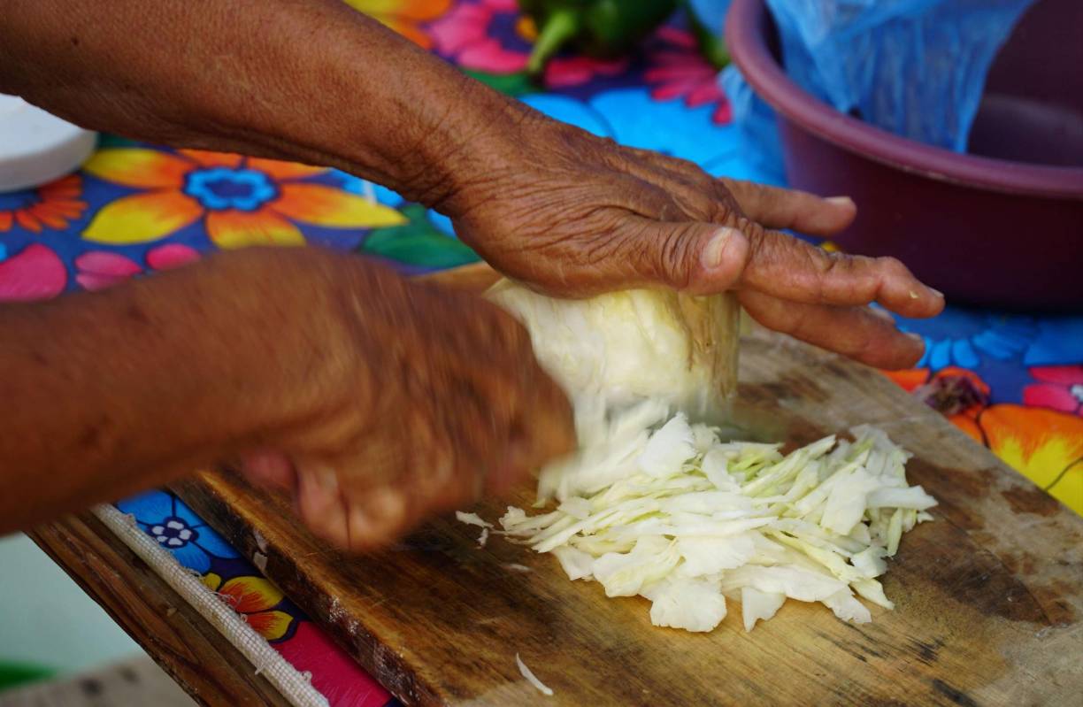 Sus pasteles llevan repollo y lo pica al instante. Su encurtido es tradicional, con ingredientes naturales y un toque picante que ya todos le conocen.