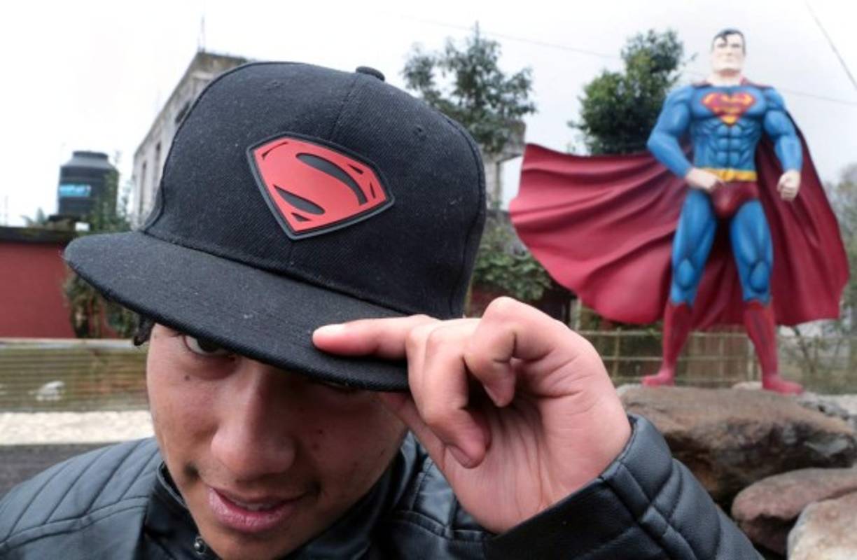 Un admirador de Supermán le ride homenaje al pie de su figura.