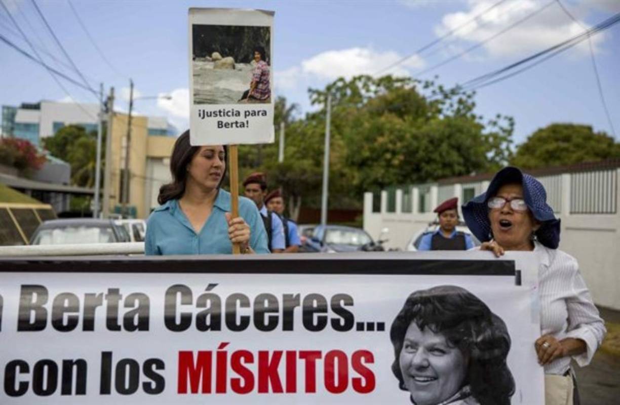 Dos mujeres sostienen una pancarta con la imagen de la ambientalista hondureña Berta Cáceres durante un plantón en los alrededores de la embajada de Honduras en Nicaragua, en Managua (Nicaragua). Representantes de grupos ambientalistas y feministas realizaron hoy un plantón en Nicaragua para demandar justicia para la líder indígena hondureña Berta Cáceres, asesinada a balazos en su vivienda el 3 de marzo de 2016, sin que hasta ahora el caso haya sido esclarecido. EFE/Jorge Torres.