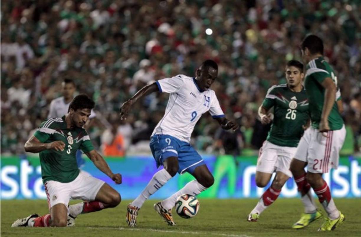 Alberth Elis, que entró en el segundo tiempo, trata de eludir a tres mexicanos.