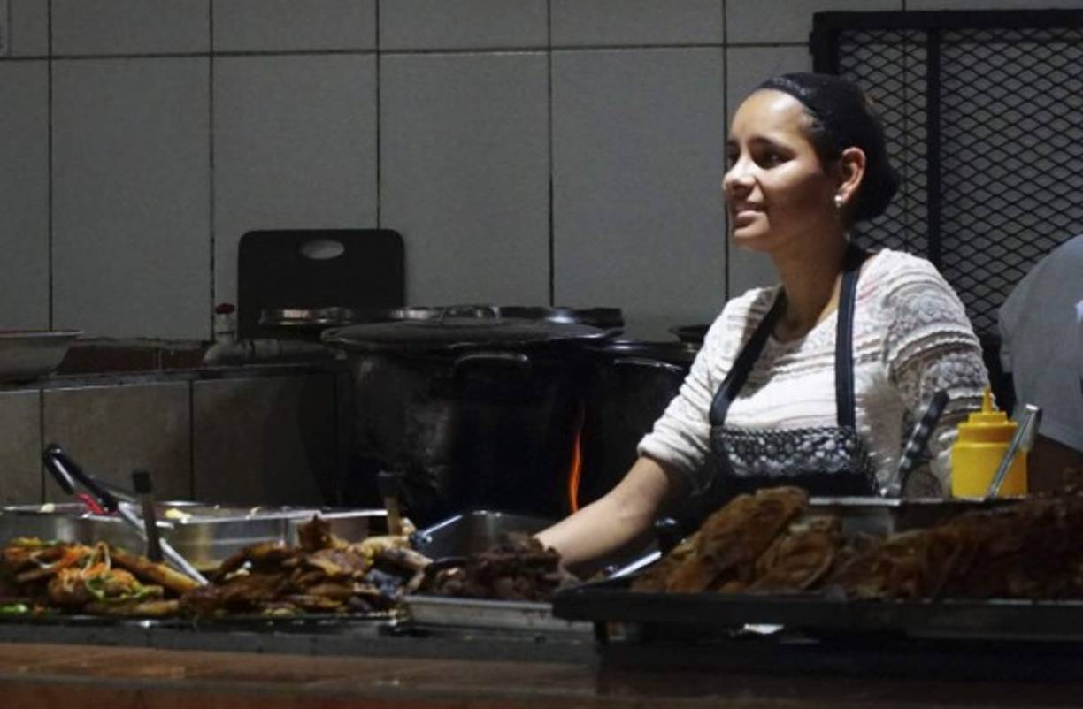 Esta joven trabaja cocinando deliciosa comida hondureña.