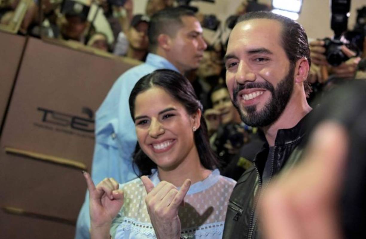 Salvadorean presidential candidate Nayib Bukele (R), of the Great National Alliance (GANA), and his wife Gabriela Rodriguez, pose after voting during the Salvadorean presidential election at a polling station in San Salvador, on February 3, 2019. - Polls opened Sunday in El Salvador's presidential elections amid heavy security as voters look for change in a country beset by gang violence and widespread poverty. (Photo by Marvin RECINOS / AFP)