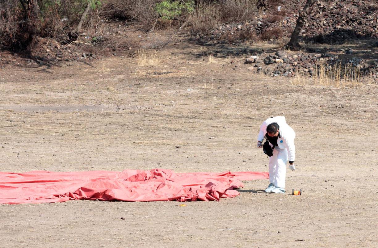 Peritos forenses laboran en la zona donde se desplomo un globo aerostático.