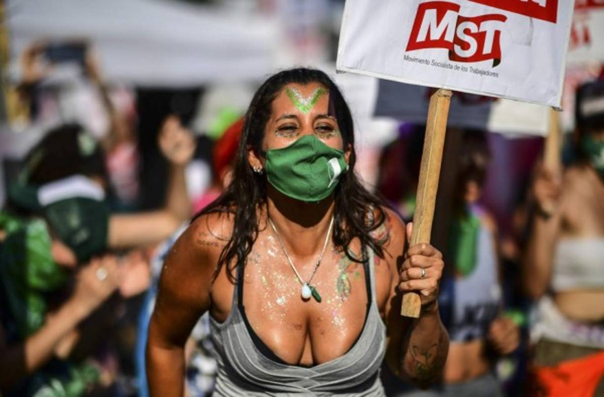 Junto a su hermana Claudia y su amiga Flor, una mujer trans de 35 años, se toman fuertemente de las manos frente a una pantalla gigante en el exterior del Congreso que transmitía en vivo la sesión de los senadores.