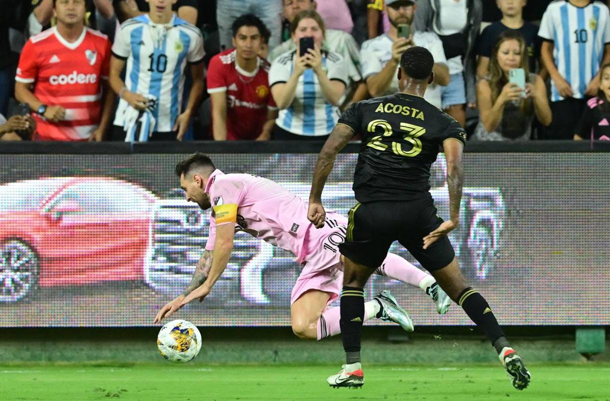 Kellyn Acosta le comete una falta a Leo Messi, al fondo aficionados graban la jugada con sus celulares.