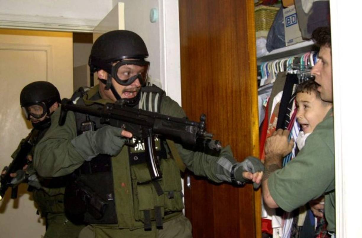 Tras seis meses de disputas legales, la fiscal general de EEUU en ese entonces, Janet Reno, dio la orden para que agentes federales irrumpieran en el domicilio en Miami resguardado por los exiliados cubanos para llevarse a Elián.<br/><br/>Una imagen captada por el fotógrafo hispano Alan Díaz, muestra a un pequeño Elian de 6 años en brazos de uno de los pescadores que lo salvaron, Donato Dalrymple, aterrorizado ante el uniformado con casco y unas enormes gafas protectoras les apunta con un arma de guerra.