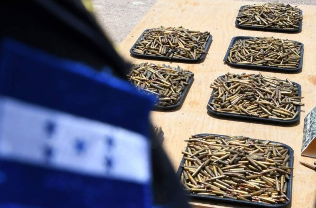 Juan Orlando Hernández destacó que las armas y los restos de cuatro persona localizados días atrás en el mismo edificio, 'da la razón de que esta gente estaba en condiciones de poder enfrentar de manera violenta'. AFP