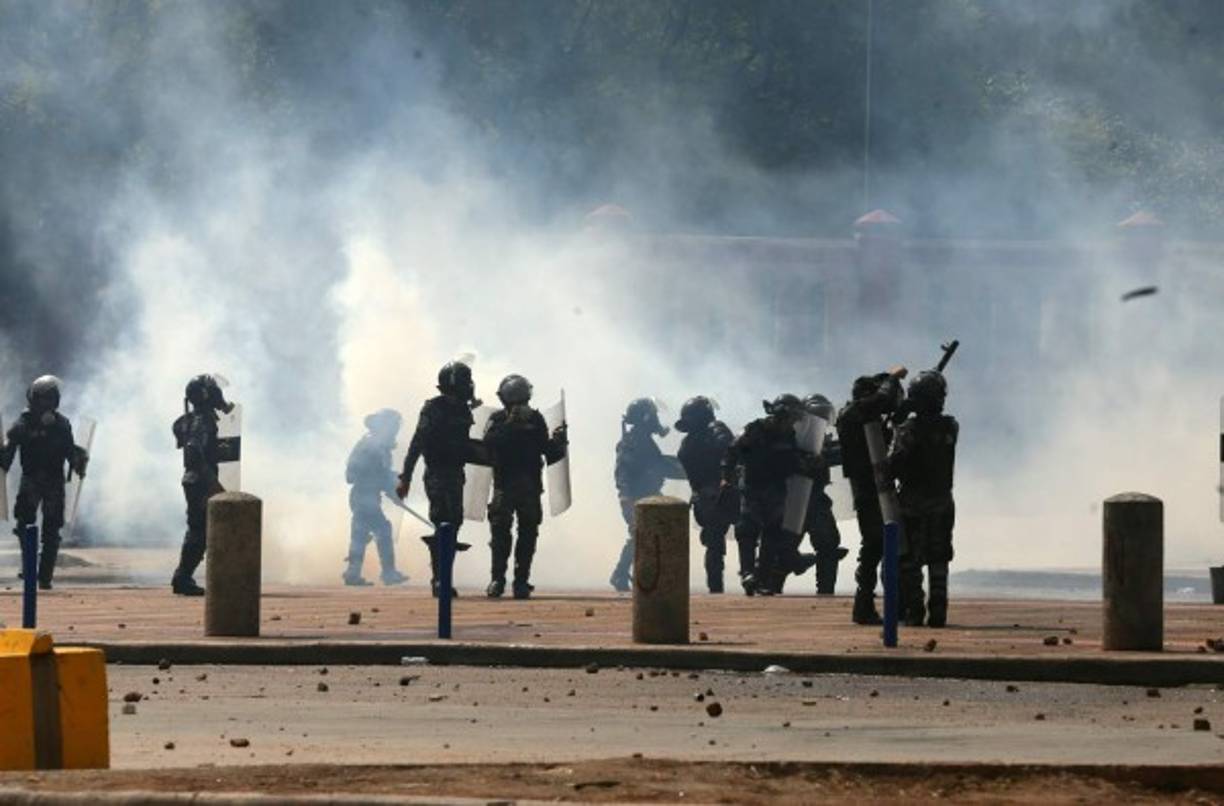 Los agentes usaron máscaras antigases debido a la gran cantidad de gas lacrimógeno que utilizaron para dispersar a los estudiantes.