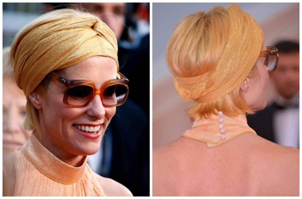 Parker Posey y un look extravagante con gafas de sol y un turbante que acompañan su rostro en tonos naturales.