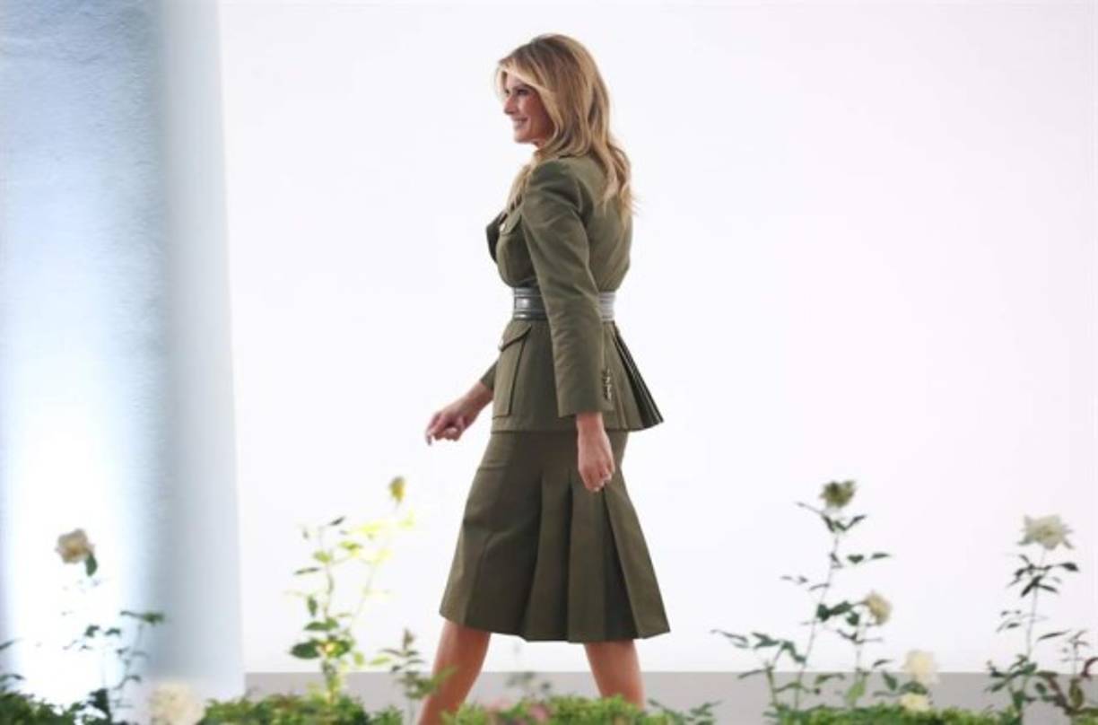 El traje de chaqueta con falda de color verde kaki recordaba las chaquetas militares de los soldados y una falda tubo que combino con sus tradicionales tacones de aguja. Su look entero estaba valorado en unos 3,000 dólares.