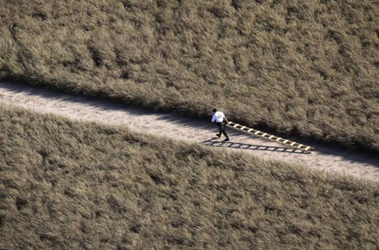 Un agente retira una escalera que utilizaron inmigrantes para escalar el muro en Arizona e ingresar ilegalmente a EUA. El magnate republicano Donald Trump ha prometido construir un muro a lo largo de toda la frontera sur de EUA para evitar el ingreso de inmigrantes ilegales.