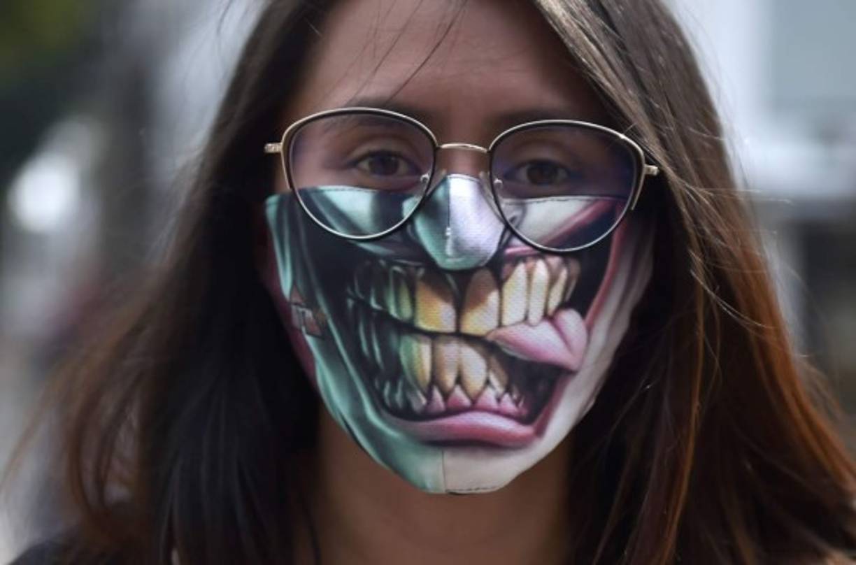 Una mujer usa una curiosa mascarilla como medida preventiva contra la propagación del nuevo coronavirus, COVID-19, en Bogotá. Foto AFP