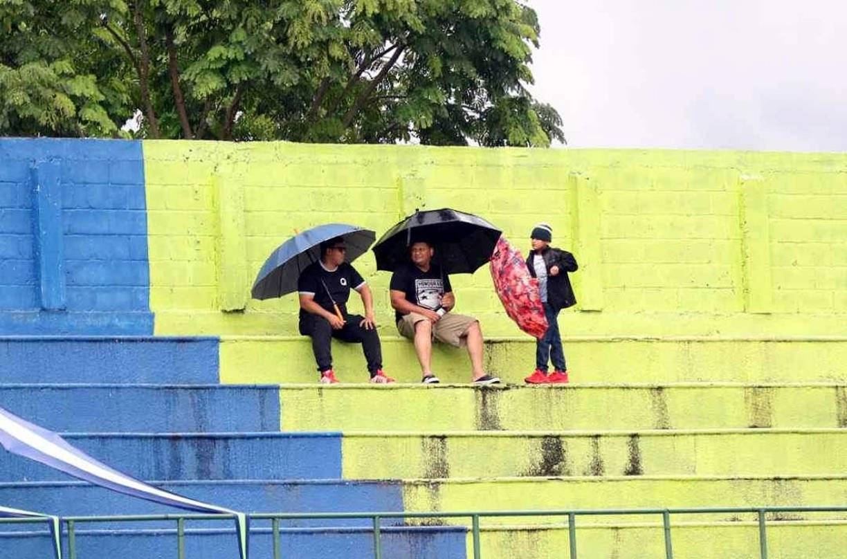 Los aficionados en Olancho tuvieron que sacar las sombrillas para protegerse de la lluvia en el estadio Juan Ramón Brevé Vargas.