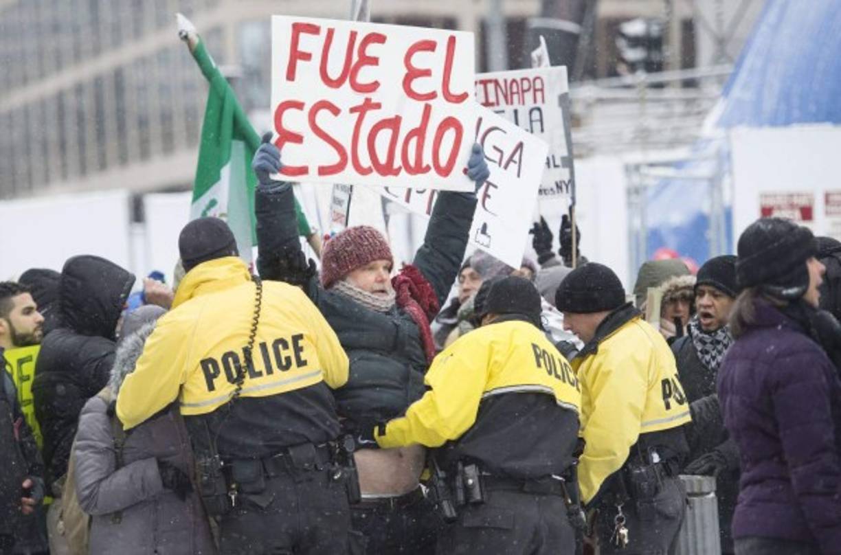 Los manifestantes exigían a Peña la aparición con vida de los normalistas de Ayotzinapa desaparecidos desde el 26 de septiembre de 2014 en Iguala, Guerrero, y le gritaban asesino.