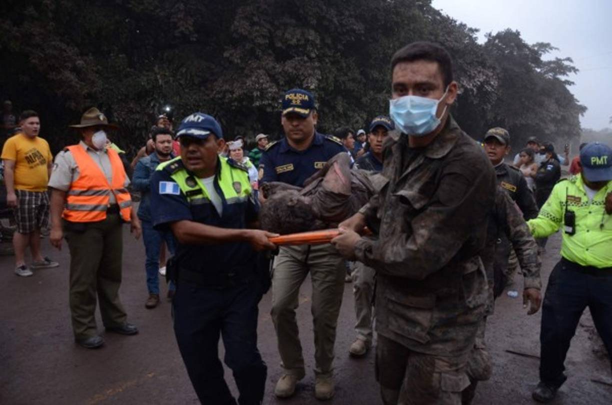 Un grupo de trabajadores de los equipos de rescate de Guatemala trasladan a un herido en El Rodeo, Escuintla. EFE/NOE PÉREZ