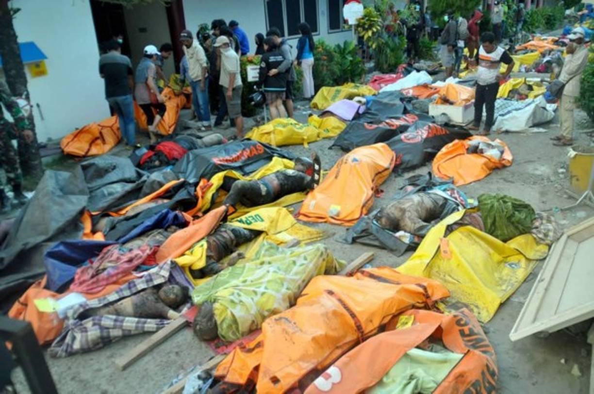 Voluntarios indonesios excavaron una fosa común para enterrar a las cientos de víctimas, mientras los socorristas trataban para sacar a más supervivientes de entre los escombros.