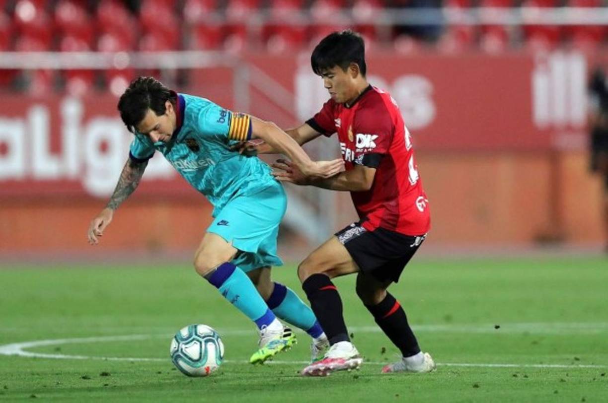 Messi siendo marcado por el japonés Takefusa Kubo del Mallorca.