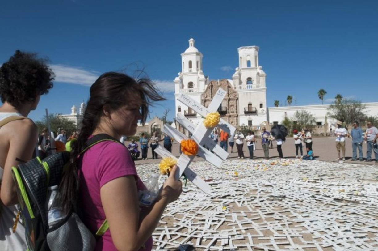 Varios manifestantes observan un círculo de cruces a las afueras de la Misión San Xavier en Tucson, Arizona, donde recuerdan a los miles de inmigrantes que han muerto en su intento por llegar a Estados Unidos.