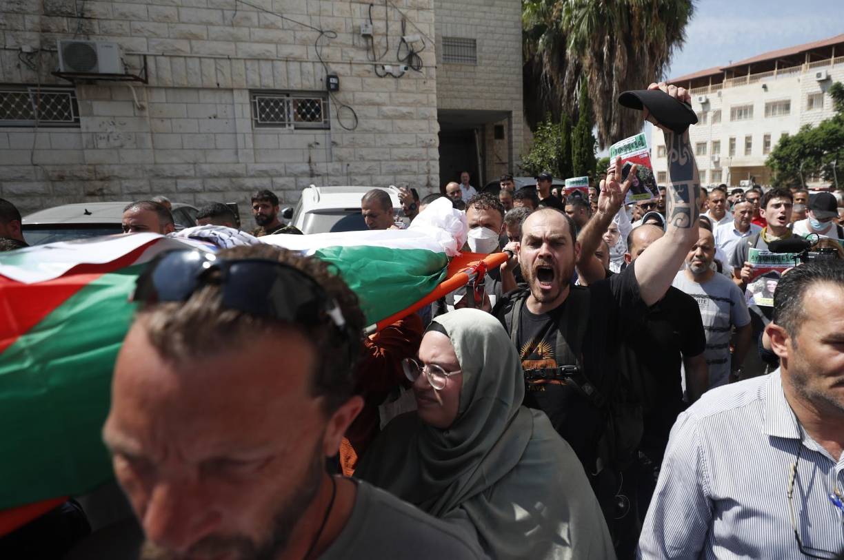 Con el cuerpo envuelto en una bandera palestina y el rostro rodeado de una kufiya, la activista de 26 años fue cargada en una camilla a través de la procesión, primero por guardias de honor con uniforme verde y luego por sus amigos más cercanos. 