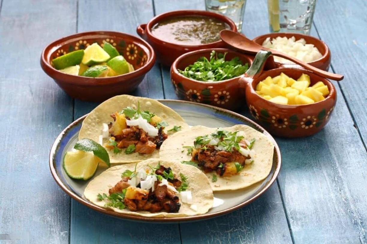 1. Tacos al pastor y baleadas: un duelo de saboresComenzamos con dos clásicos: los tacos al pastor de México y las baleadas de Honduras. Los tacos al pastor, con su carne de cerdo marinada y asada, acompañada de piña, cebolla y cilantro, son perfectos para compartir.