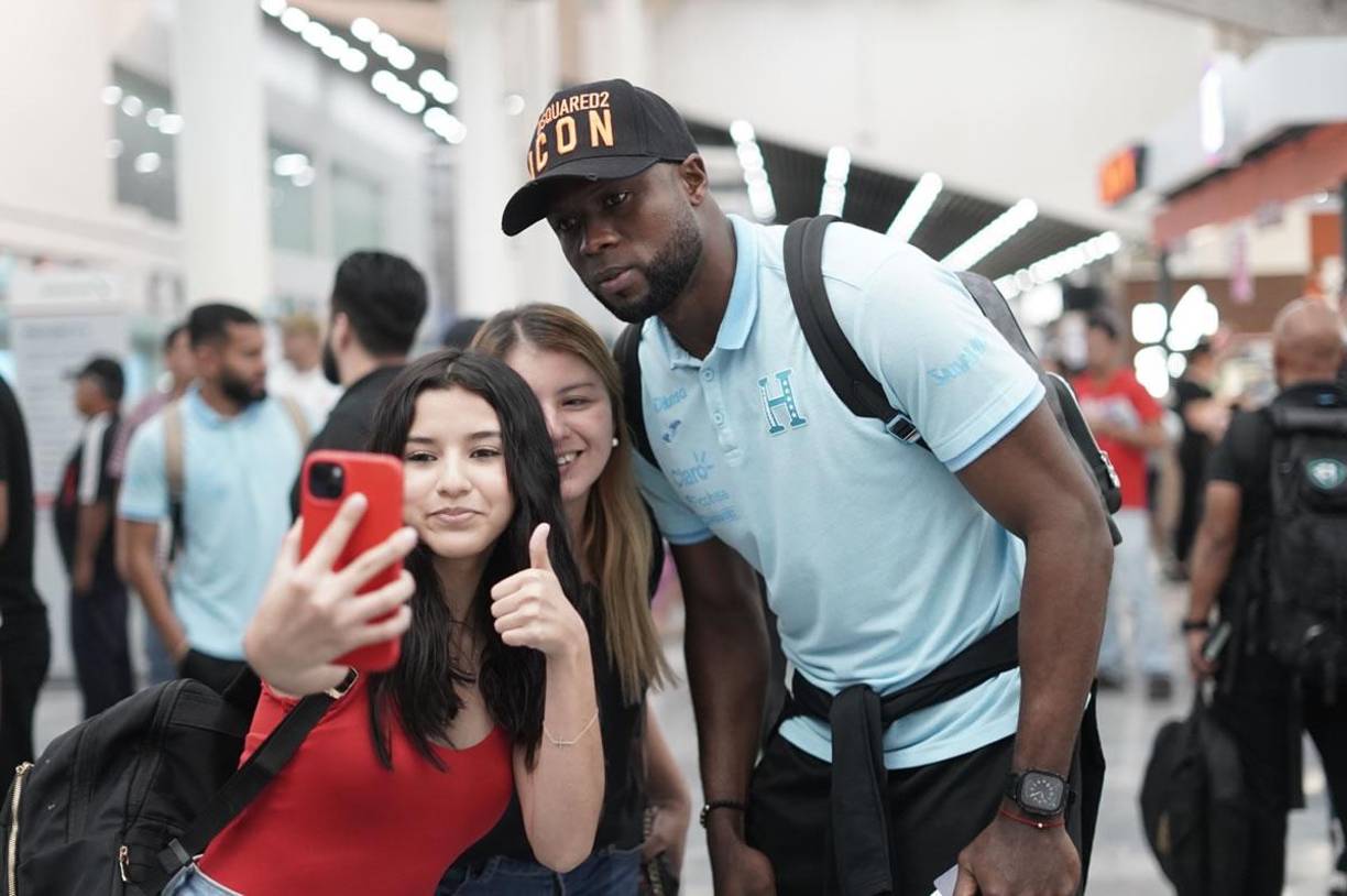 Yustin Arboleda posando con dos aficionadas que le pidieron una selfie en la terminal aérea.