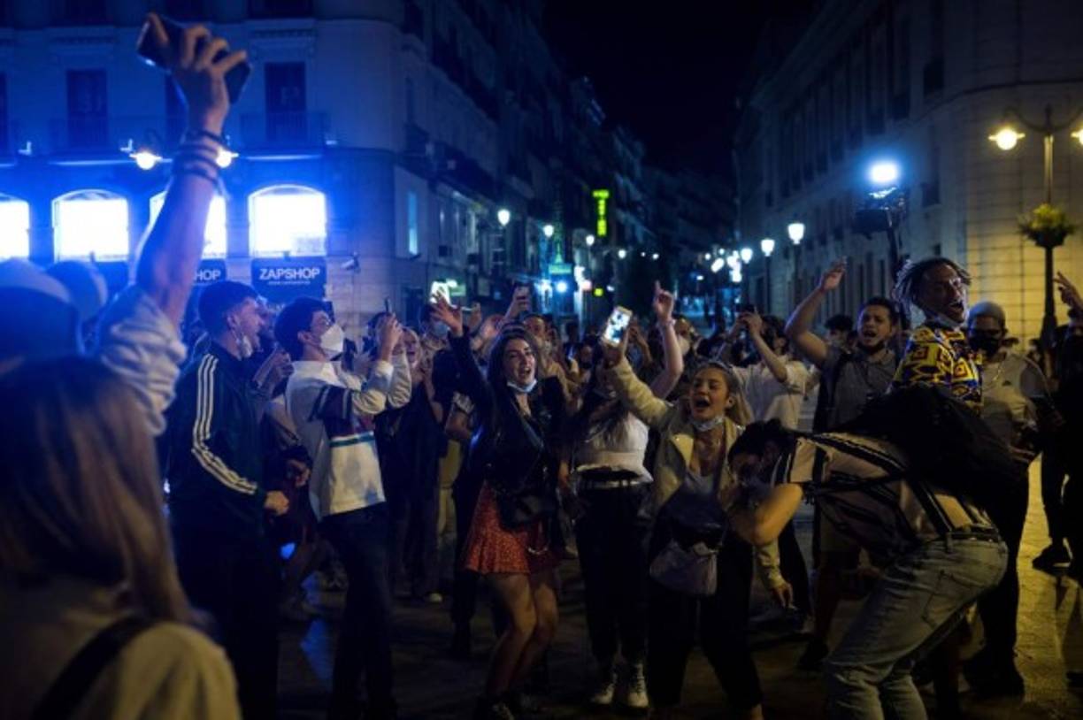En Madrid, la primera noche sin estado de alarma ni toque de queda fue una multitudinaria celebración de miles de jóvenes bebiendo, y bailando en las calles y plazas más céntricas de la capital, que parecían festejar la Nochevieja.