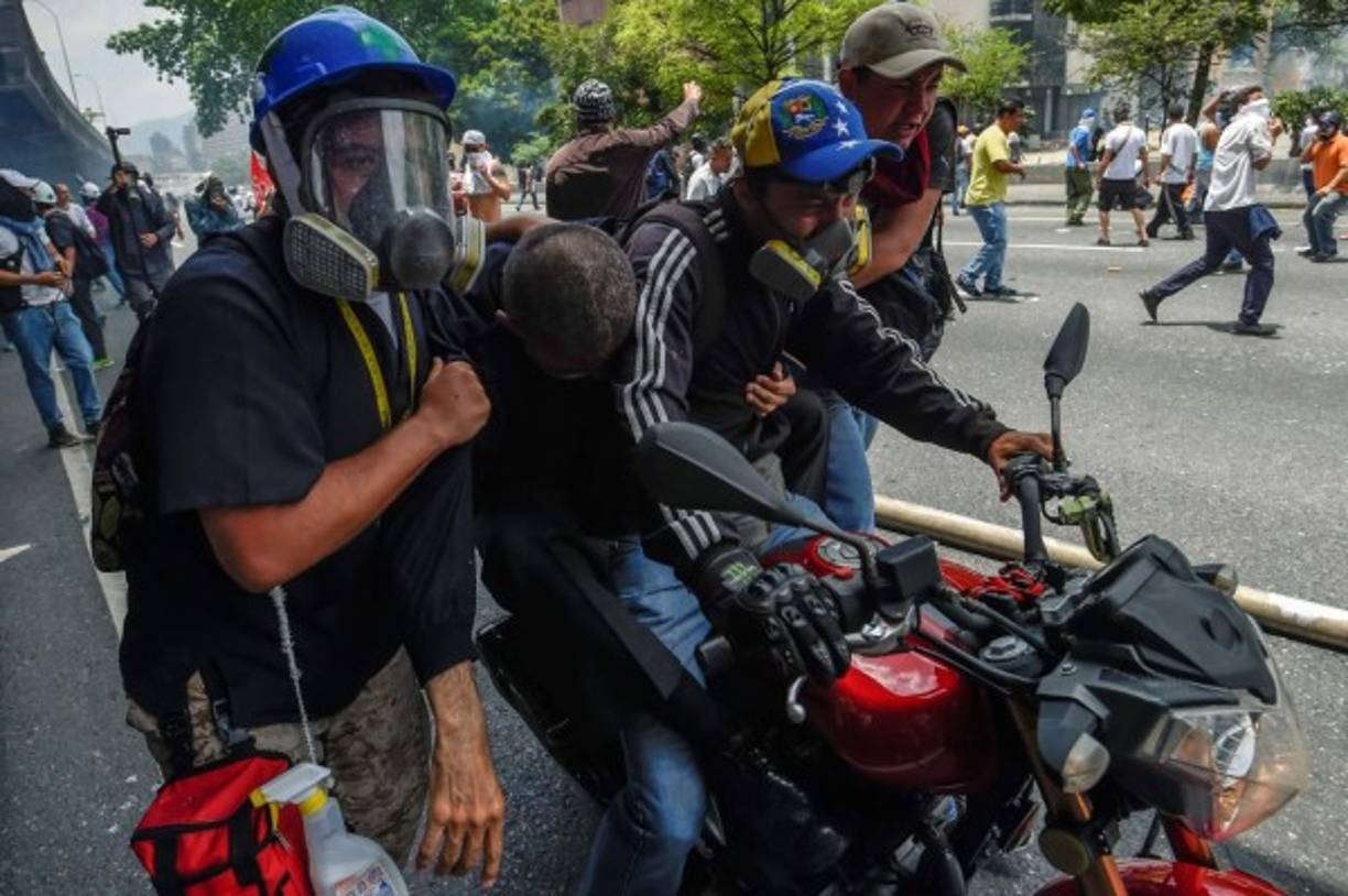 Los enfrentamientos entre la policía y manifestantes que les tiraban piedras estallaron en una estratégica autopista y en varios sectores del oeste de Caracas, así como en ciudades de los estados de Zulia, Carabobo, Táchira, Mérida y Anzoátegui.