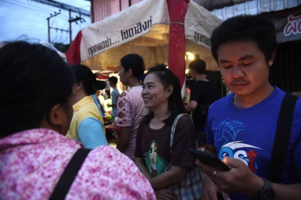 People wait near the hospital as ambulance transporting members of the children's football team arrives in the northern Thai city of Chiang Rai on July 10, 2018 after being rescued in Tham Luang cave.<br/>All 12 boys and their coach who became trapped in a flooded Thai cave more than a fortnight ago have been rescued, the Navy SEALs announced on July 10, completing an astonishing against-the-odds rescue mission that has captivated the world. / AFP PHOTO / Lillian SUWANRUMPHA
