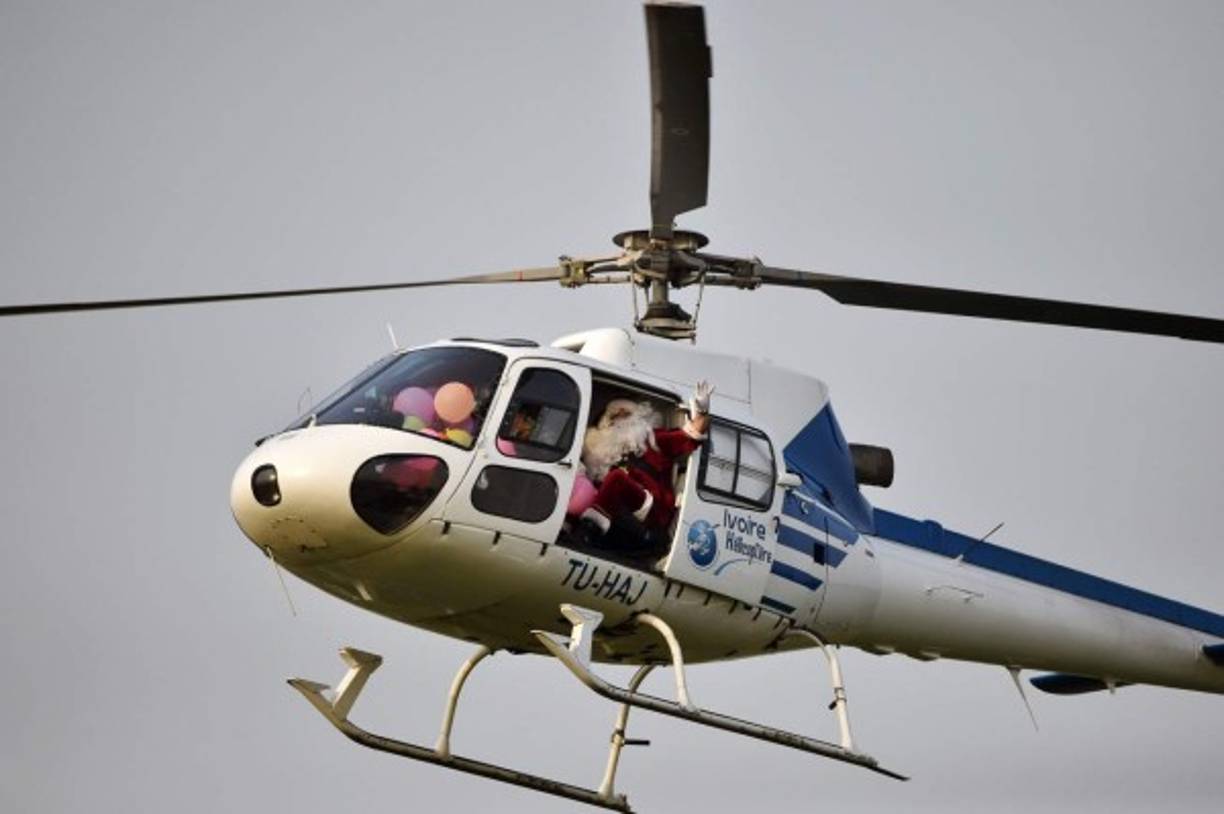 Al arribar al palacio de Abidjan en Costa de Marfil, Santa aterrizó en un helicóptero para atender a más de 3000 niños en una reunión organizada por la primera dama de ese país.