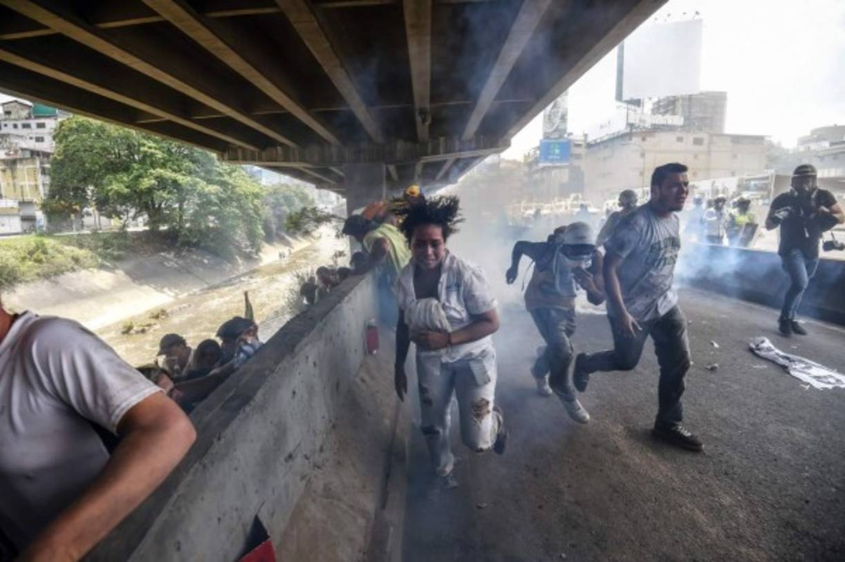 Manifestantes huyen de la policía durante una de las protestas en Caracas.