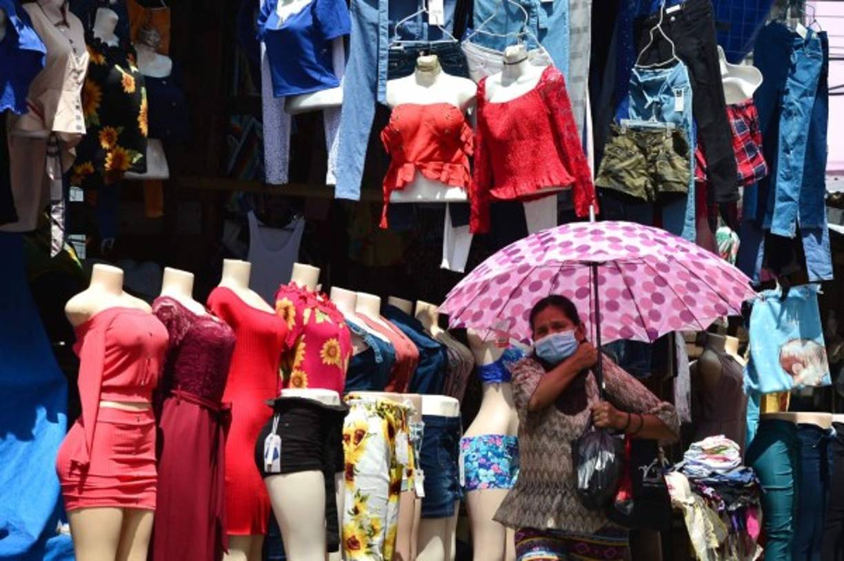 Una mujer usa una mascarilla facial en un mercado del centro de Tegucigalpa durante la pandemia COVID-19. AFP