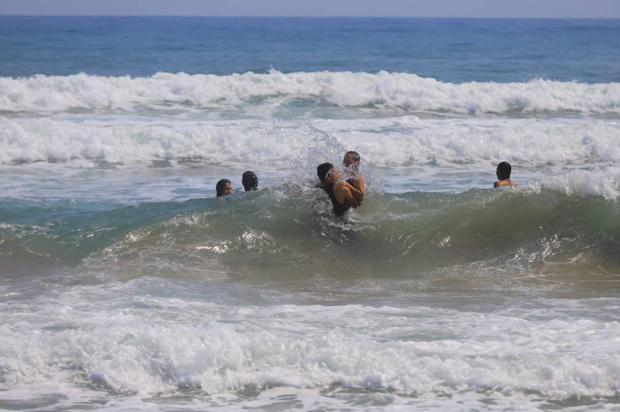 Los hondureños disfrutan que las olas golpeen sus cuerpos.